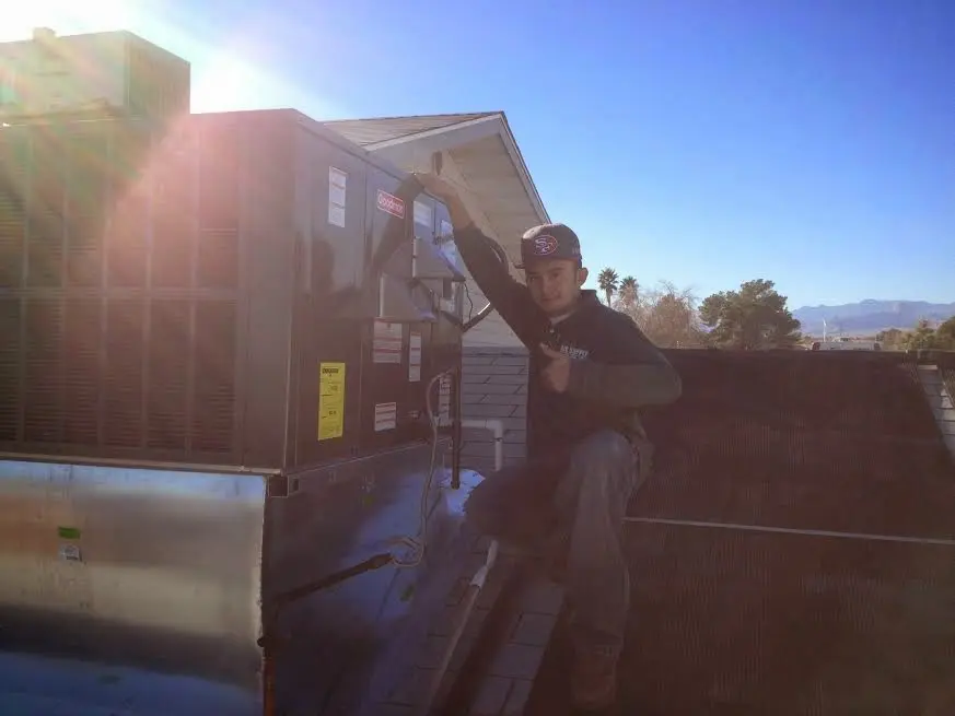 HVAC technician performing AC Tune-Up on a rooftop unit in Leawood
